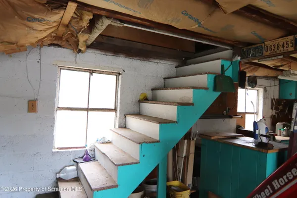a view of a house with a large tree and wooden fence