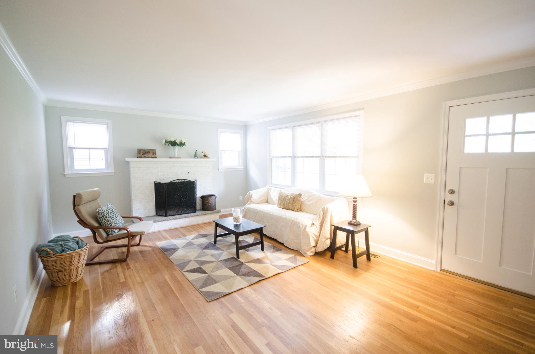 1007 Roxleigh Road Baltimore, MD 21286 - Photo 5 of 29 a living room with furniture a fireplace and a table