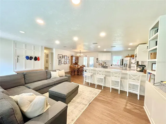 a living room with furniture and a view of kitchen