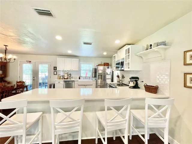 a large white kitchen with lots of appliances and furniture