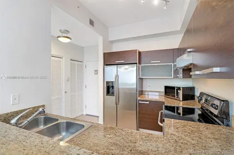 a kitchen with stainless steel appliances granite countertop a refrigerator and a sink