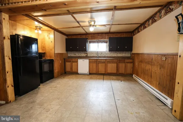 an empty room with windows and chandelier fan