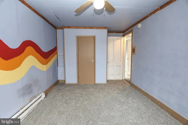 an empty room with windows and ceiling fan