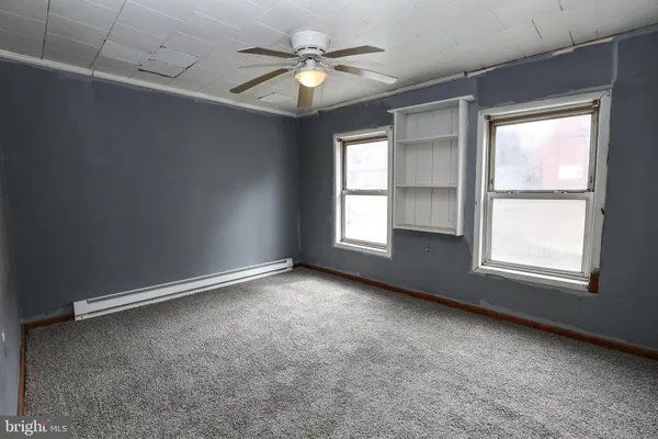 an empty room with windows and closet