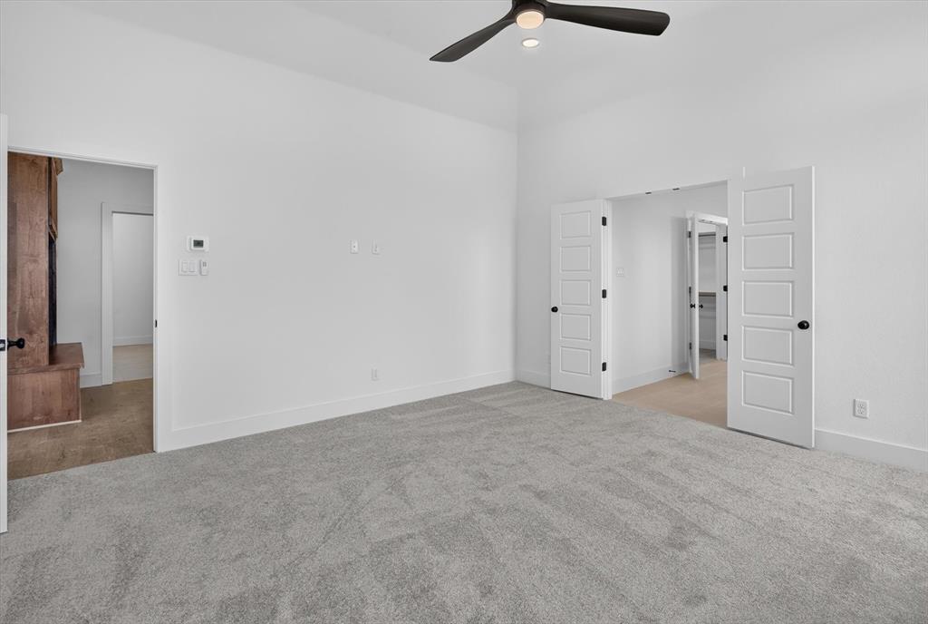 471 Red Bird Drive Springtown, TX 76082 - Photo 18 of 35 Spacious room featuring vaulted ceilings, light gray carpet flooring, a ceiling fan with integrated lighting, and white baseboards