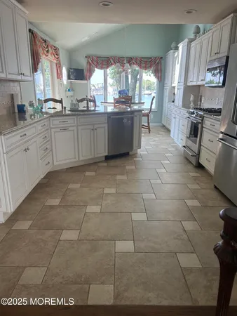 a kitchen with stainless steel appliances a sink a stove a microwave and cabinets
