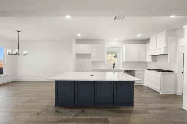 a kitchen with a sink cabinets and wooden floor