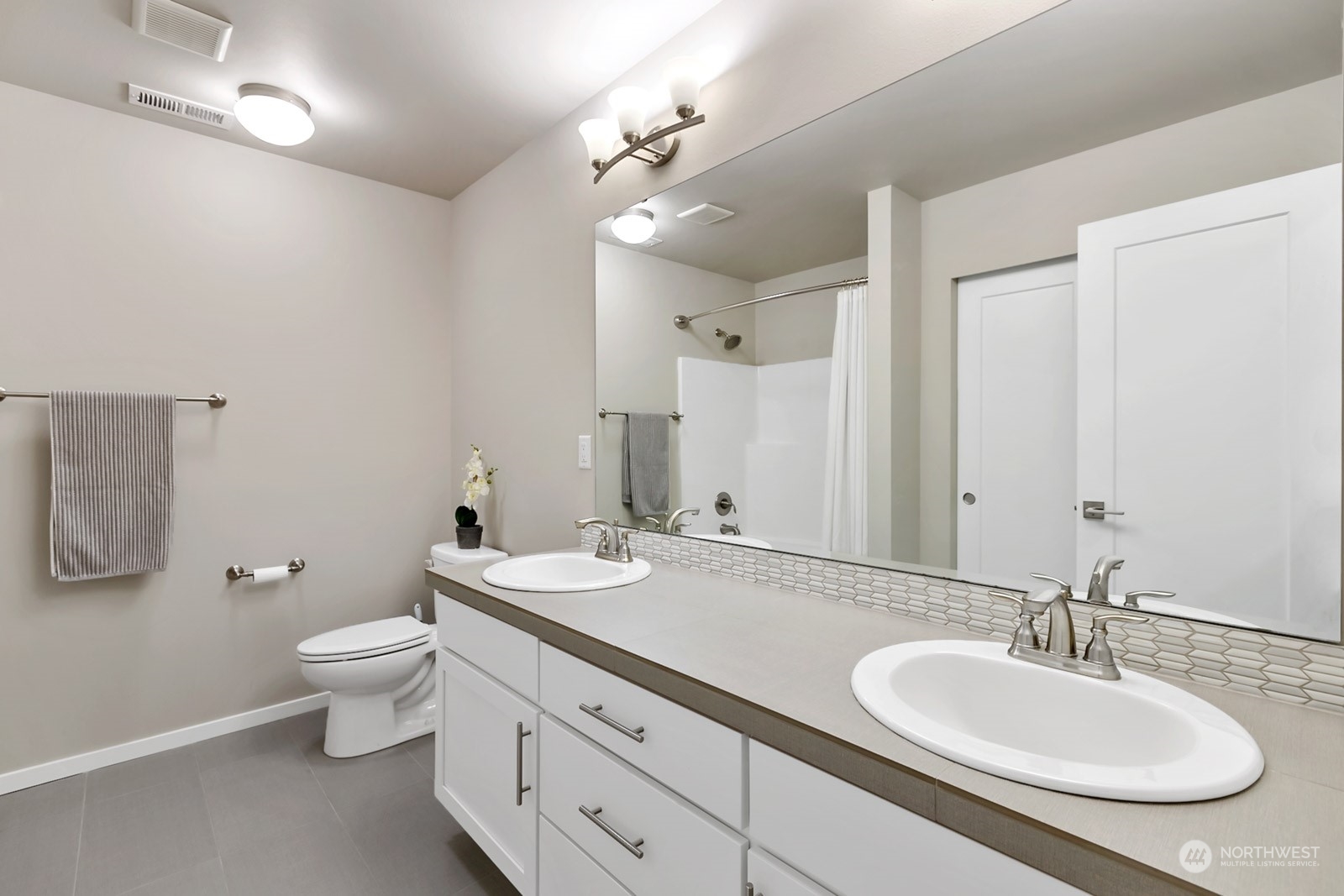 853 South 49th Street Renton, WA 98055 - Photo 23 of 35 a bathroom with a double vanity sink toilet and a mirror