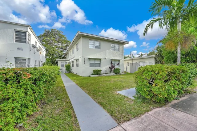 a view of a house with backyard and sitting area