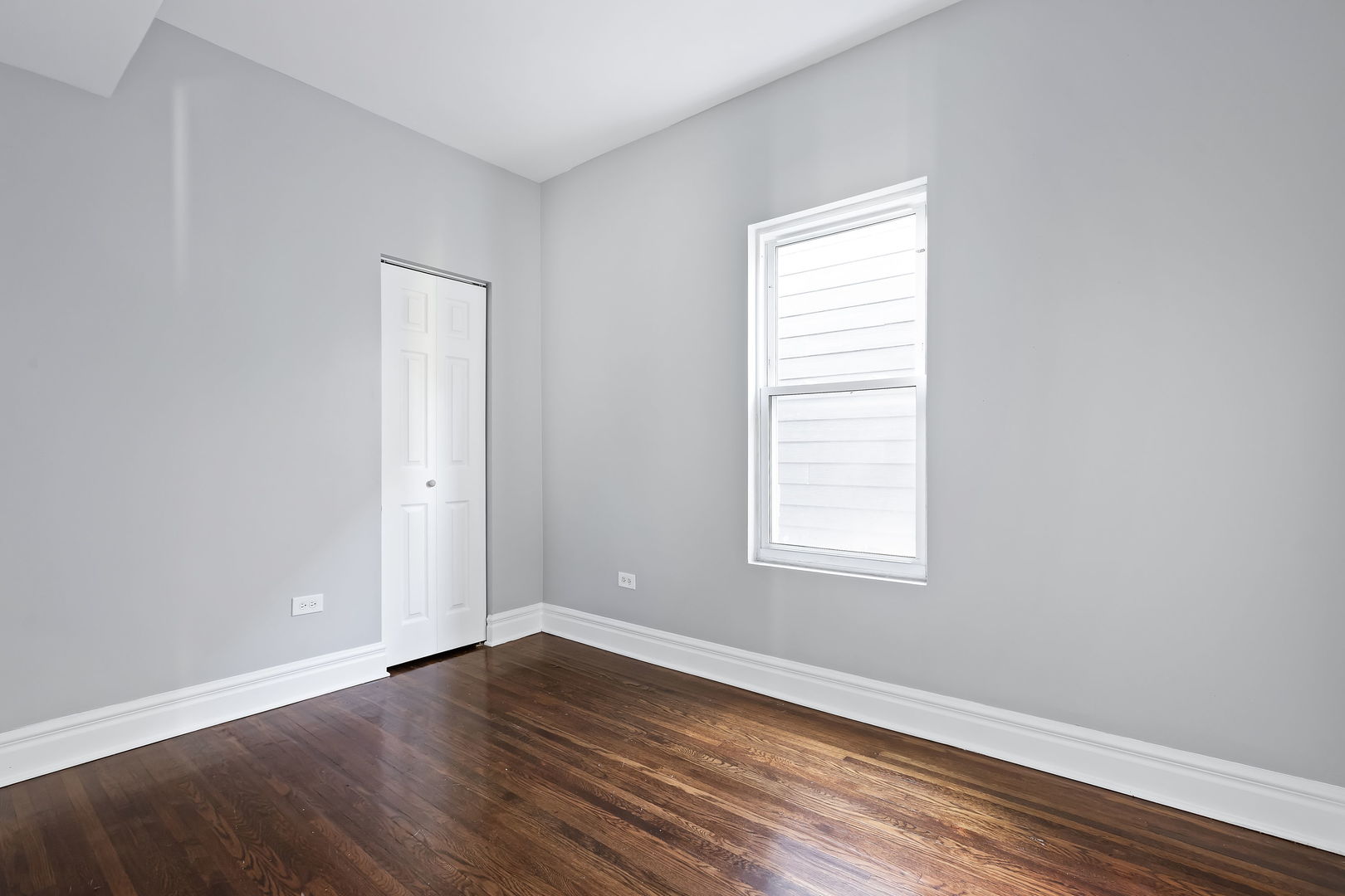 6321 South Champlain Avenue Chicago, IL 60637 - Photo 11 of 14 an empty room with wooden floor and windows