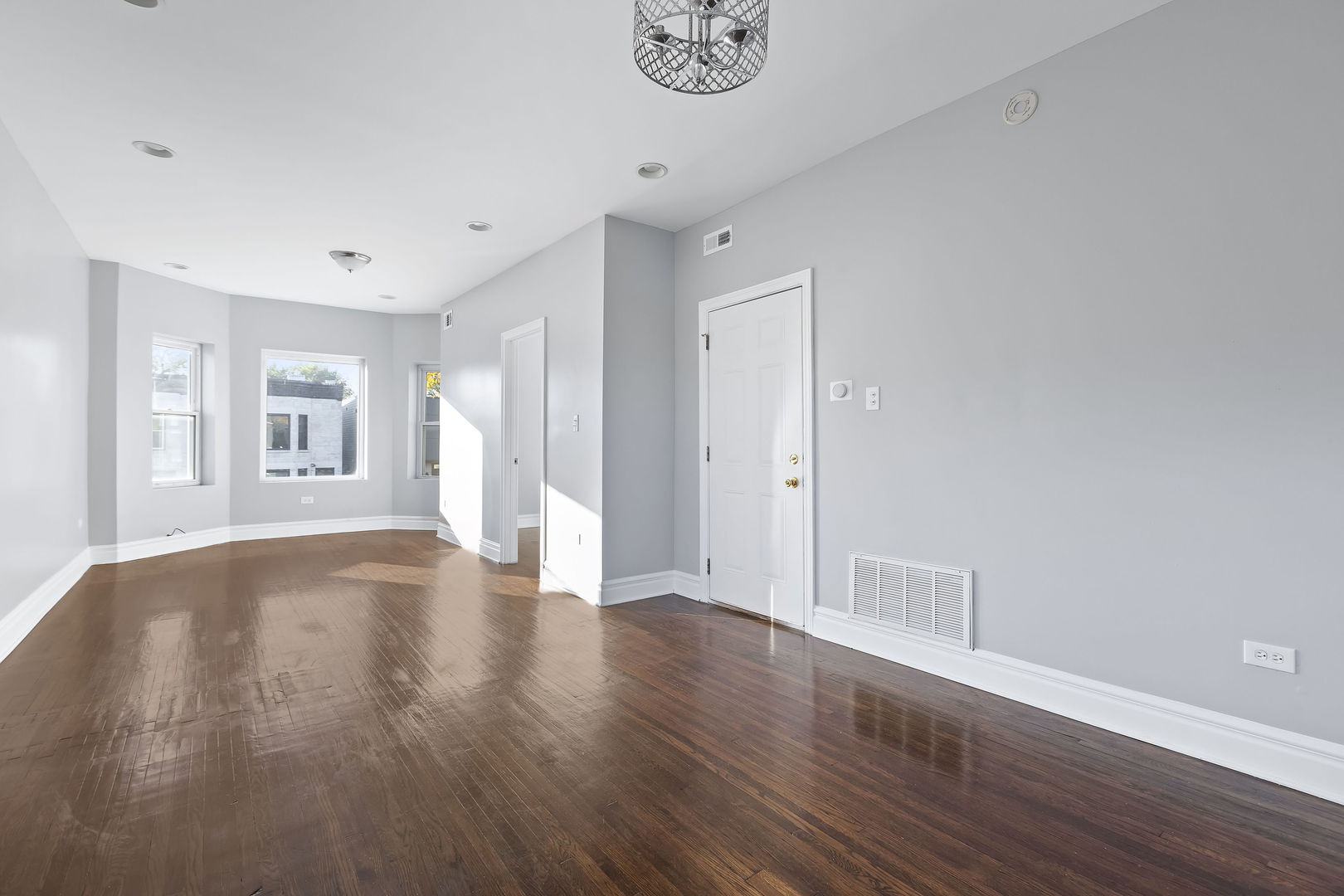 6321 South Champlain Avenue Chicago, IL 60637 - Photo 8 of 14 a view of an empty room with wooden floor and a window