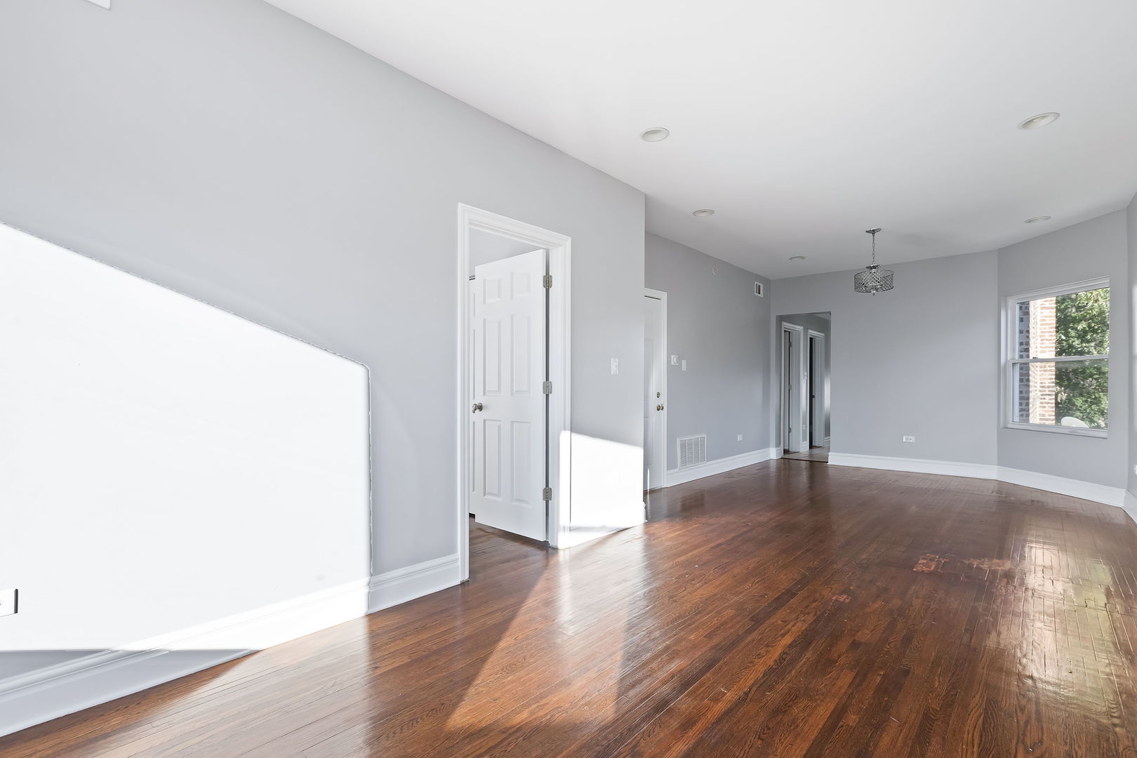6321 South Champlain Avenue Chicago, IL 60637 - Photo 9 of 14 a view of an empty room with wooden floor and a window