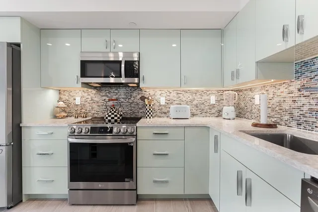 a kitchen with white cabinets stainless steel appliances and sink