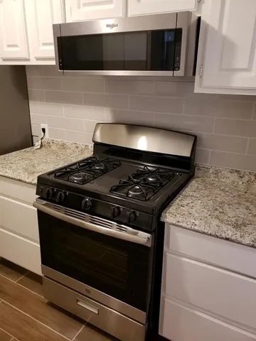 a stove top oven sitting inside of a kitchen