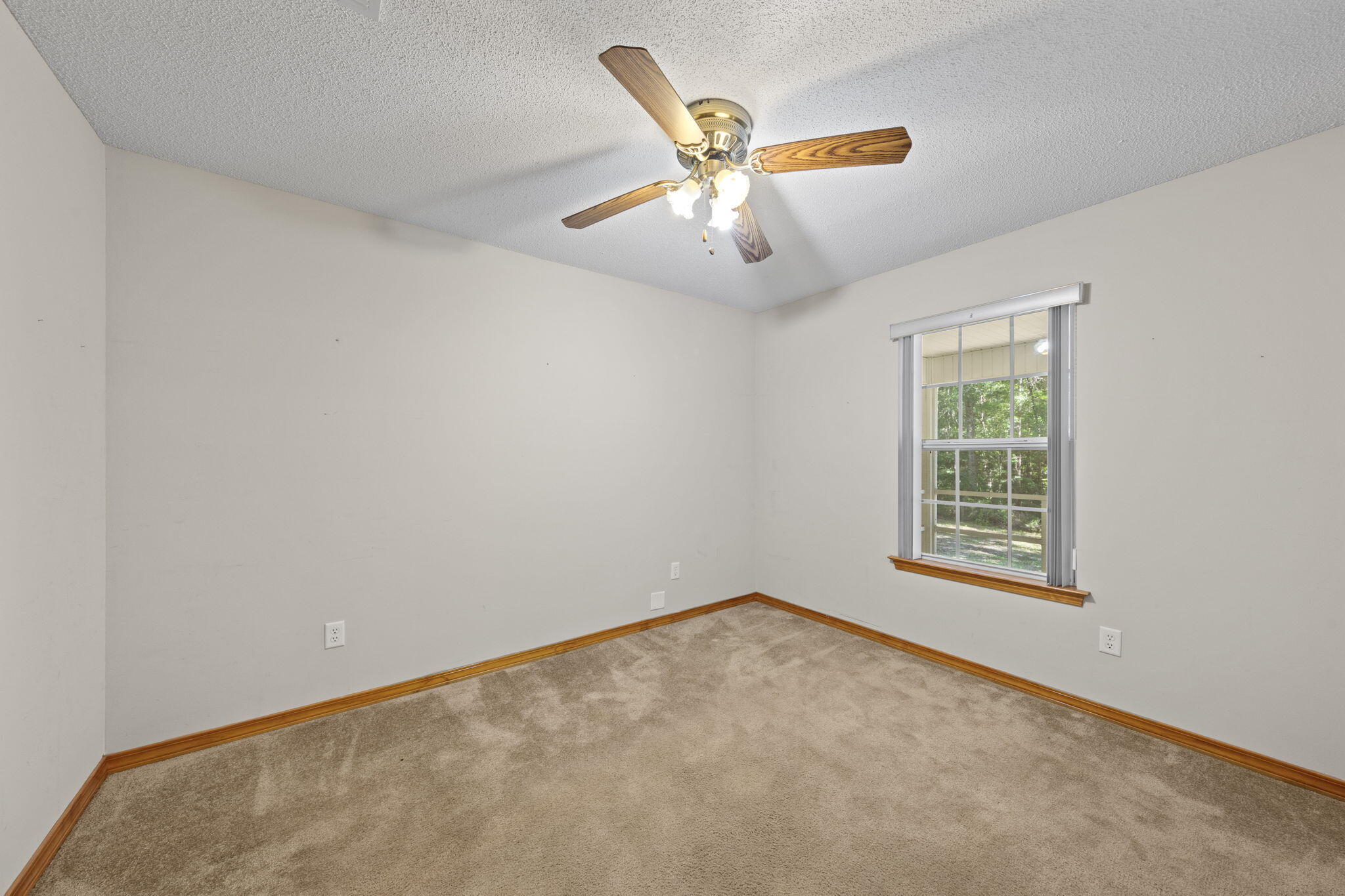 3435 Fl-2 Laurel Hill Laurel Hill, FL 32567 - Photo 16 of 39 an empty room with a window and a fan