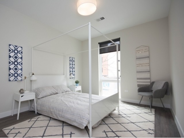 4027 North Broadway, Unit 504 Chicago, IL 60613 - Photo 5 of 7 a bedroom with a bed and a chair