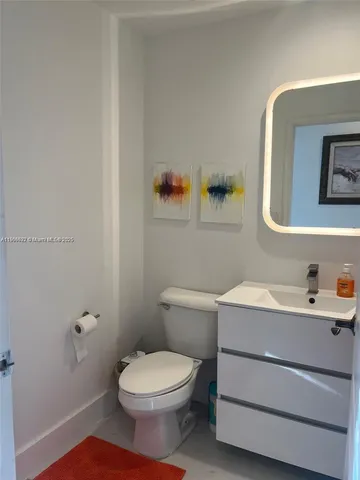 a bathroom with a toilet a sink and mirror
