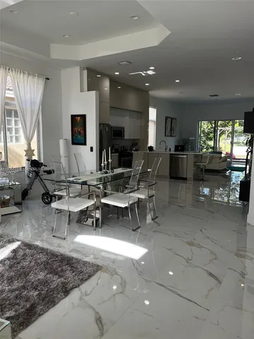 a living room with patio furniture and a large window