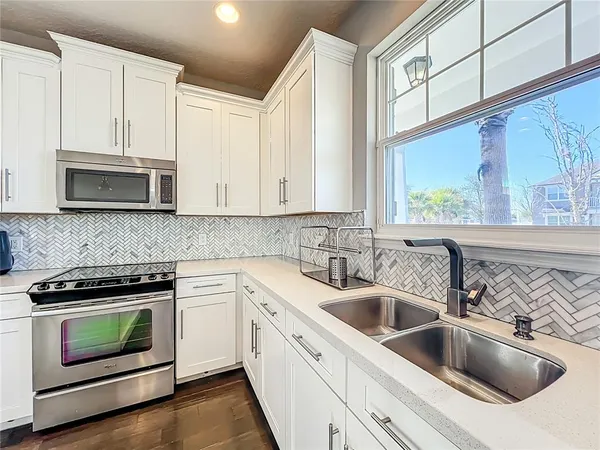 a kitchen with white cabinets stainless steel appliances and sink