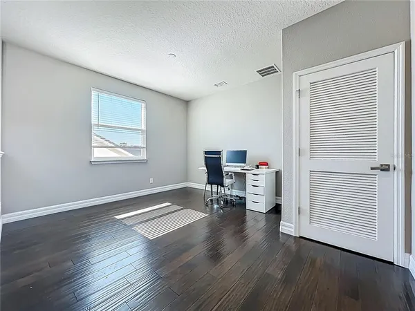 a bed sitting in a bedroom next to a window