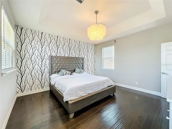 a bedroom with a bed and wooden floor
