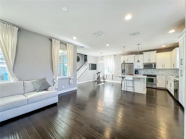 an open kitchen with white cabinets and stainless steel appliances