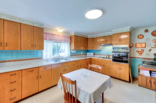 a kitchen with stainless steel appliances granite countertop a sink a stove and a refrigerator