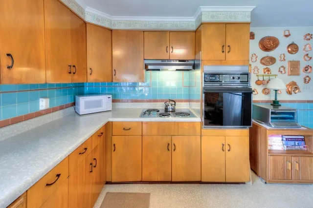 a kitchen with stainless steel appliances granite countertop a table chairs sink and cabinets