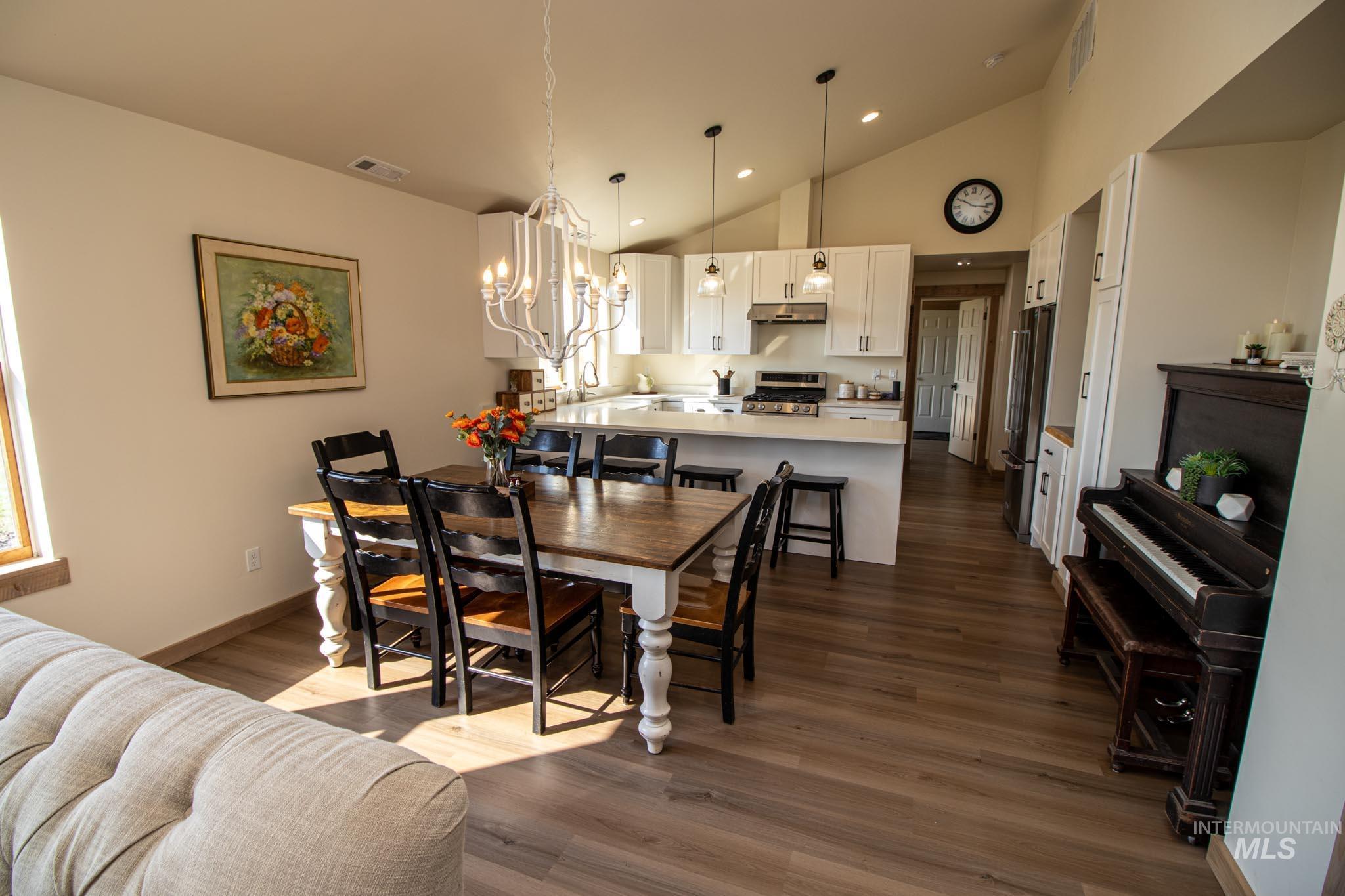 263 Glory Lane Orofino, ID 83544 - Photo 8 of 48 Dining area featuring vaulted ceiling, a chandelier, and dark wood finished floors