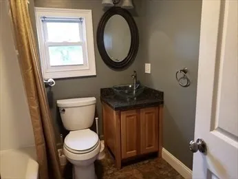 a bathroom with a toilet a sink and a mirror