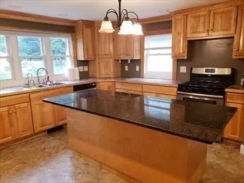 a kitchen with granite countertop a stove and a sink