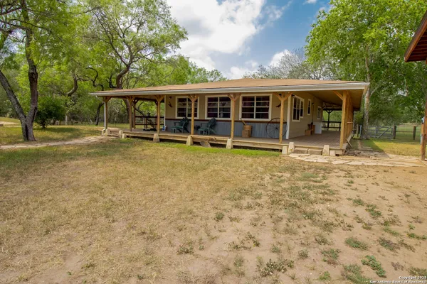 front view of house with a yard balcony and swimming pool