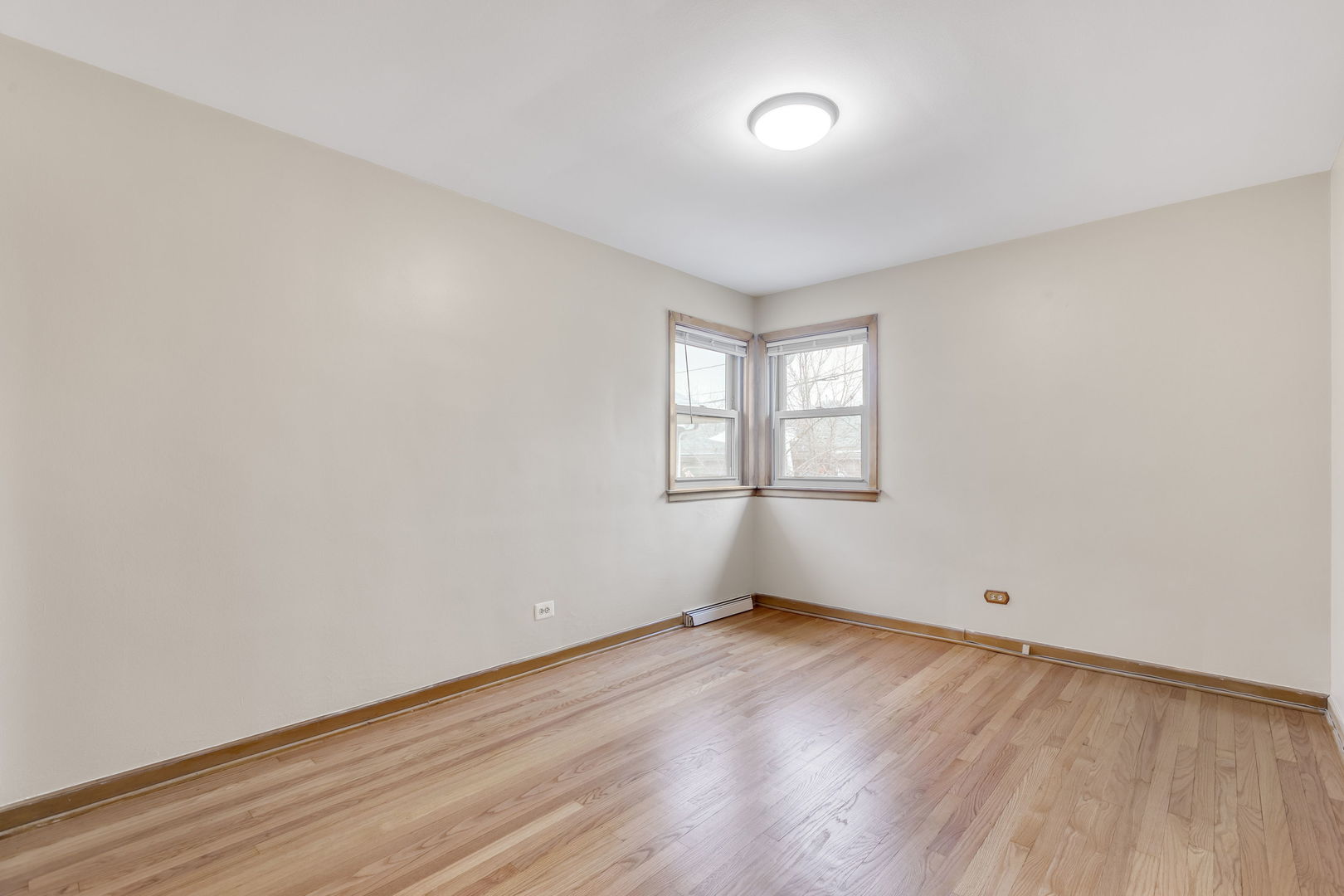 3253 North Austin Avenue Chicago, IL 60634 - Photo 9 of 16 an empty room with wooden floor and windows