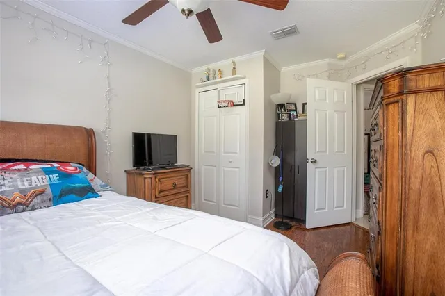 a bedroom with a bed and a flat tv screen on dresser