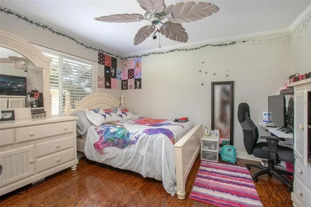 a bedroom with a bed and a flat tv screen on the dresser