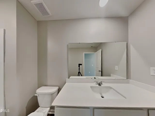 a bathroom with a sink a toilet and mirror