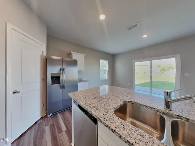 a kitchen with granite countertop a sink and a refrigerator