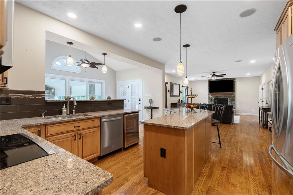 192 Baldwin Road Carnegie, PA 15106 - Photo 15 of 50 a large kitchen with stainless steel appliances kitchen island granite countertop a sink dishwasher a stove and a dining table with wooden floor