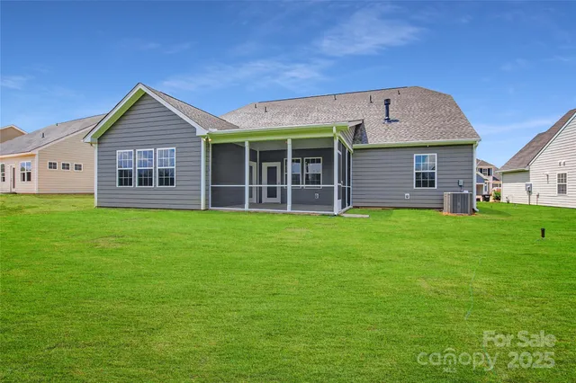 a view of a house with a yard and large tree