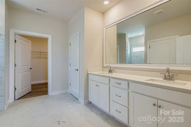 a spacious bathroom with double sink and a mirror