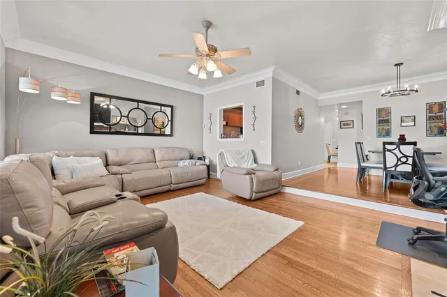 a living room with furniture kitchen view and a large window