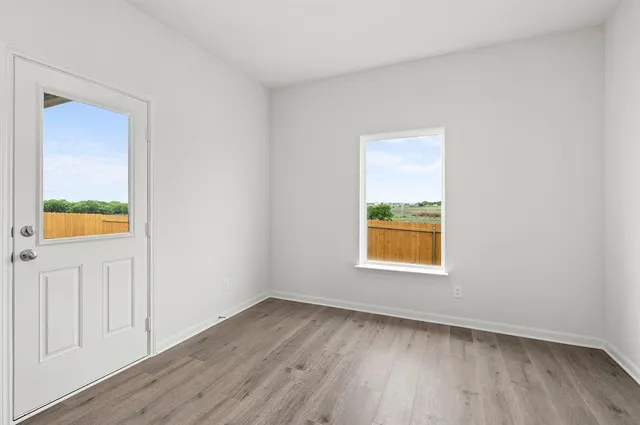 an empty room with window and wooden floor