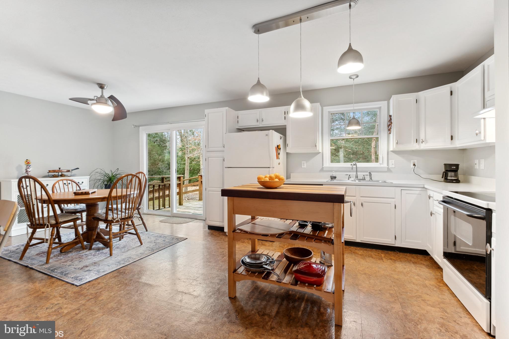 12934 Parran Drive Lusby, MD 20657 - Photo 2 of 21 a kitchen with a dining table chairs and white cabinets