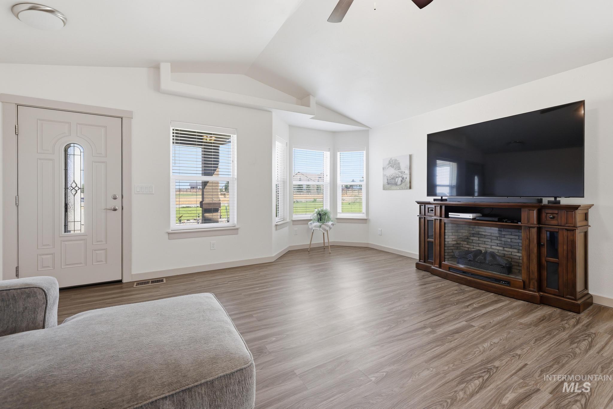 178 Syringa Loop Shoshone, ID 83352 - Photo 6 of 35 Bright living area featuring wood-finish flooring, a decorative bay window, and a vaulted ceiling