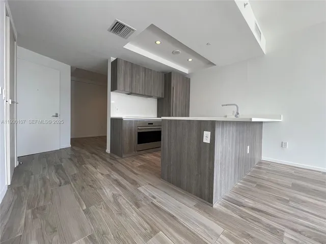 a view of a kitchen with wooden floor and electronic appliances