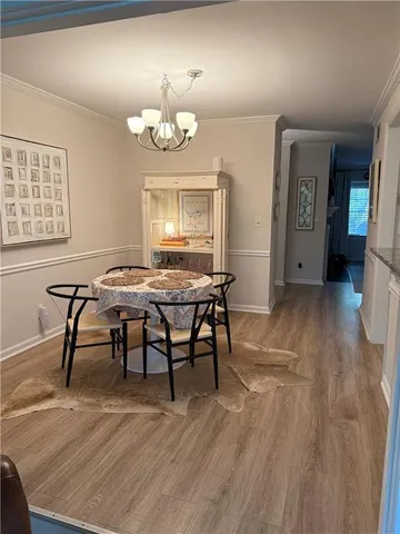 a view of a kitchen with a refrigerator a stove top oven and a wooden floor
