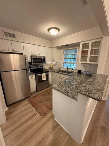 a kitchen with refrigerator a microwave and stove
