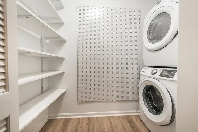 an empty room with chandelier fan and windows