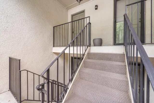 a view of a hallway with wooden floor and a living room