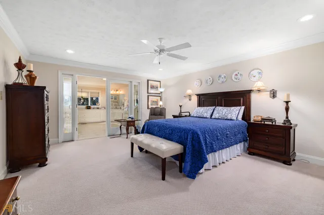 a bedroom with a bed a dresser and a large window